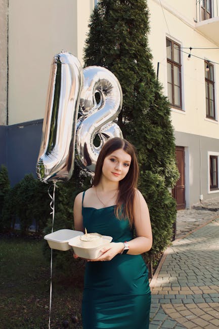 Young woman celebrating her 18th birthday with silver balloons